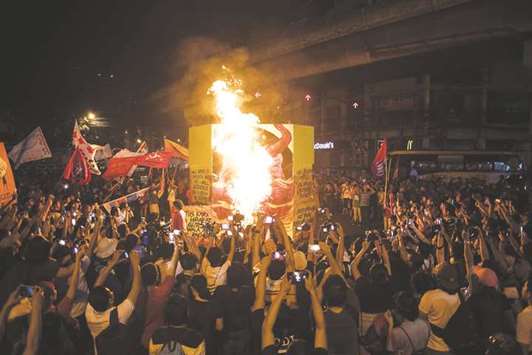 Activists burn an effigy of President Rodrigo Duterte during a protest in Manila yesterday, as they commemorate the International Human Rights Day.