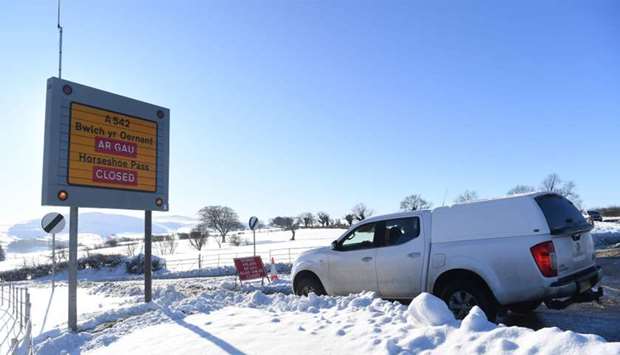 A sign alerts drivers to road closures near Wrexham, north Wales as heavy snowfall blankets the area