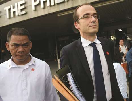Thomas Triomphe (right), Asia-Pacific head of French pharmaceutical giant Sanofi, is escorted by security personnel after attending a Senate hearing in Manila yesterday.
