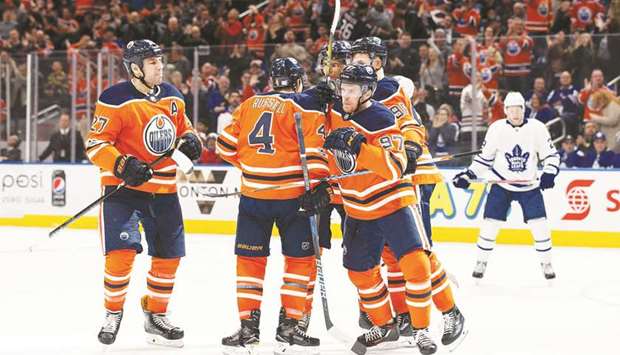 Milan Lucic #27, Kris Russell #4 and Connor McDavid #97 of the Edmonton Oilers celebrate McDavidu2019s goal against the Toronto Maple Leafs at Rogers Place in Edmonton, Canada.