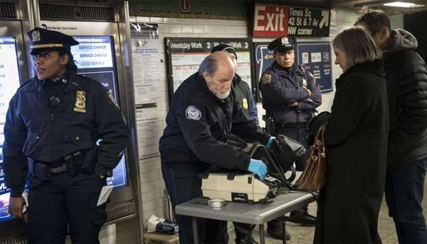 Members of the Transportation Security Administration and New York City Police Department check the bags of passengers as they enter the Times Square subway station