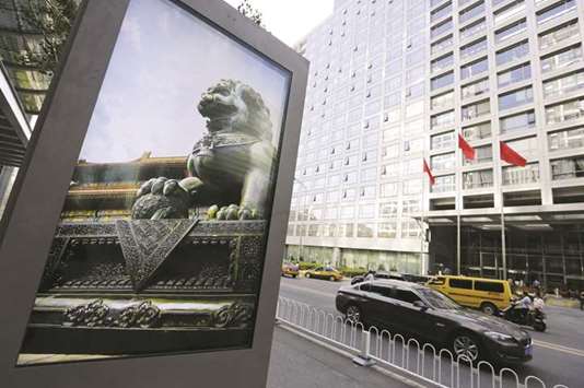 An advertising board (left) showing a Chinese stone lion is pictured near an entrance to the headquarters (right) of China Securities Regulatory Commission in Beijing. Chinau2019s securities regulator revised rules at the beginning of September, doing away with the need for individuals to hold a companyu2019s shares before buying the debt.