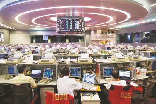 Traders work at the Hong Kong Stock Exchange. The Hang Seng closed down 0.6% to 28,793.88 points yesterday.