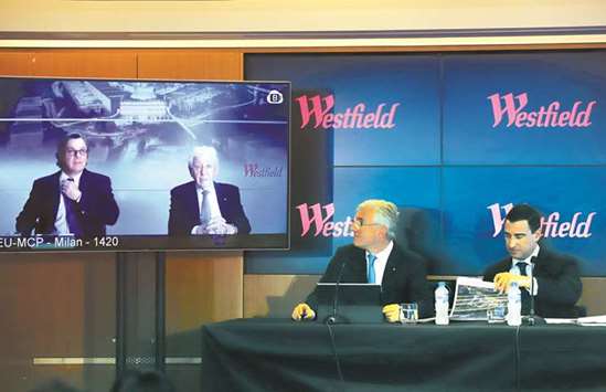 Westfield chairman and co-founder Frank Lowy appears with his son Peter on a screen via video-link, as his other son Steven Lowy sits with Elliot Rusanow, chief financial officer of Westfield, during a media conference in Sydney yesterday. The firm has been selling smaller and less-dominant assets in its European retail portfolio and reinvesting the proceeds in its development pipeline which includes larger malls which are expected to be more resilient to the growth of online shopping.
