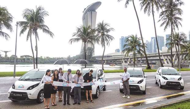 Managing director of Blue Solutions Marie Bollore (second right), Singapore transport minister Khaw Boon Wan (third right) and other BlueSG executives cut a ribbon during the launch of an electric car-sharing service in Singapore.