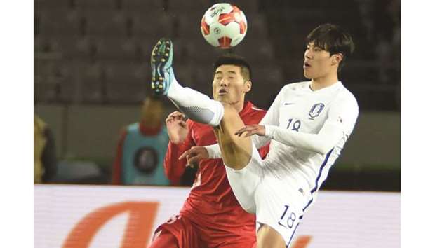 South Korean forward Jin Seonguk (R) battles for the ball with North Korean defender Ri Yong-Chol (L) during their match at the EAFF E-1 football championship in Tokyo yesterday. (AFP)