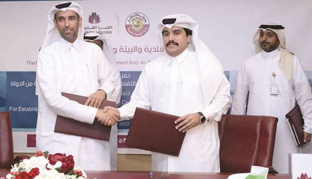 Assistant Undersecretary of Agricultural Affairs, Livestock and Fisheries at the Ministry of Municipality and Environment, Sheikh Dr Faleh bin Nasser al-Thani, exchanging documents after signing the contract with Chairman of Al Qamra Holding, Hamad al-Qamra, yesterday.