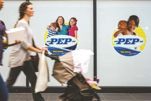 A pedestrian pushes a baby stroller past a PEP store, operated by Pepkor, a unit of Steinhoff International Holdings in Johannesburg. Steinhoff rattled creditors and investors last week by announcing accounting irregularities and the departure of its chief executive officer.