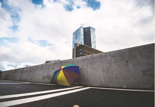 A rainbow-coloured umbrella lies discarded in a parking lot near the European Central Bank headquarters in Frankfurt. At least six banks including Nomura International and Barclays predict that President Mario Draghi will raise interest rates as soon as next year.