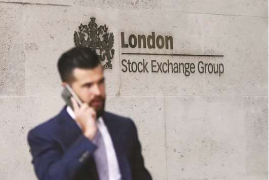 A commuter walks past the London Stock Exchange. The FTSE 100 lost 0.1% to 7,496.51 points yesterday.