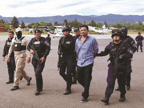 Honduran National Police officers escort Honduran drug trafficker Arnulfo Fagot Maximo in Tegucigalpa. Maximo, who was captured last August, was extradited to the US under charges of drug trafficking and accused of being a member of the u201cClan Montes Bobadillau201d crime organisation.