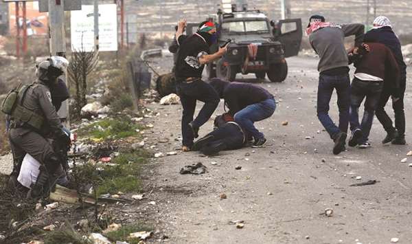 Undercover Israeli security personnel and an Israeli border policeman detain Palestinian demonstrators during clashes at a protest against US President Donald Trumpu2019s decision to recognise Jerusalem as the capital of Israel, near the settlement of Beit El, near the West Bank city of Ramallah, yesterday.