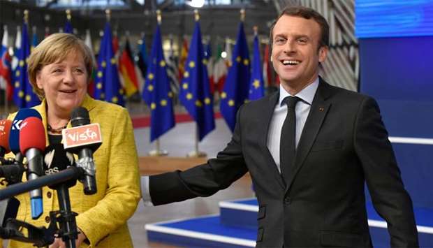 Germany's Chancellor Angela Merkel and France's President Emmanuel Macron answer the press as they arrive to attend the first day of a European union summit in Brussels