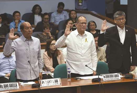 Former Philippine president Benigno Aquino, former budget secretary Florencio Abad (L), and former executive secretary Paquito Ochoa (R) take an oath during the continuing hearing on the dengue vaccine  manufactured by French pharmaceutical giant Sanofi at the Senate in Manila yesterday.