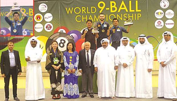 World 9-Ball Championship winner Carlo Biado (behind, right) of the Philippines, runner-up Roland Garcia (behind, left) and semi-finalist Eklent KaCi pose on the podium with QBSF president Mohamed Mubarak al-Ramzani (front, fourth from right), WPA president Ian Anderson (front, centre), QBSF secretary-general Mohamed Salem al-Nuaimi (second from left), assistant secretary-general Sultan Salem al-Suwaidi (third from right), executive manager Mubarak Hamad al-Khayarin (right) and other officials.  TOP LEFT INSERT: World 9-Ball Championship winner Carlo Biado lifts his trophy. PICTURES: Shemeer Rasheed