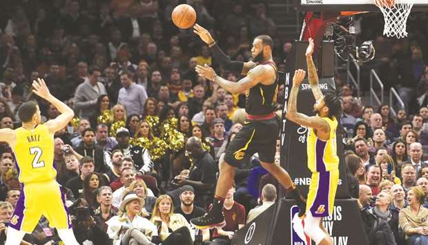 Cleveland Cavaliers forward LeBron James (centre) throws a pass between Los Angeles Lakers guard Lonzo Ball (left) and forward Brandon Ingram (right) in the second quarter at Quicken Loans Arena. PICTURE: USA TODAY Sports