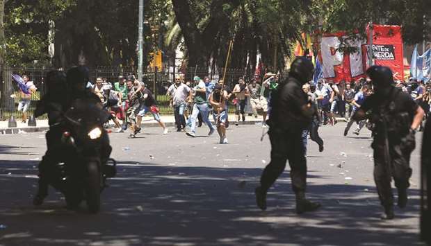 Protesters rush towards Argentine policemen outside the Congress in Buenos Aires, Argentina.