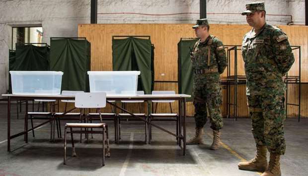 Chilean soldiers stand guard at a polling station at the Amunategui highschool in Santiago