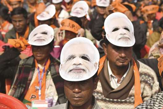 Supporters of the Bharatiya Janata Party (BJP), wearing masks of Prime Minister Narendra Modi, listen to Modi during a public rally in Shillong yesterday.