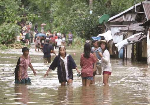 Villagers wade through a flooded street in Brgy Calingatngan, in Borongan, on eastern Samar in central Philippines yesterday.