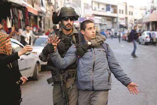 An Israeli border police officer detains a protester during a demonstration in a street in east Jerusalem.