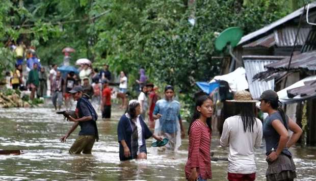 Villagers wade through a flooded street in Brgy Calingatngan, in Borongan, on easterm Samar in central Philippines