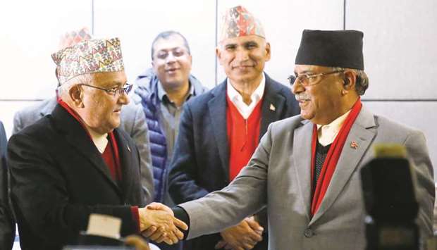 Communist Party of Nepal (Unified Marxist-Leninist) (CPN-UML) party chairman Khadga Prasad Sharma Oli, also known as K P Oli, (left) shakes hands with Communist Party of Nepal (Maoist Centre) chairman Pushpa Kamal Dahal, during a news conference in Kathmandu yesterday.