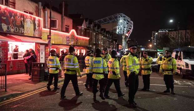 Police officers patrol the area around Old Trafford stadium