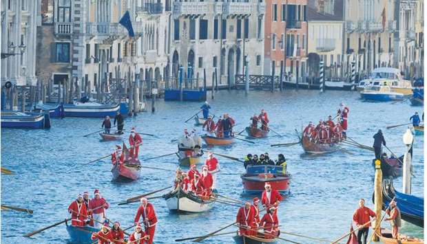 People dressed as Santa Claus and Father Christmas row during a Christmas regatta in Venice.