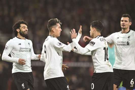 Liverpoolu2019s Brazilian midfielder Roberto Firmino (second left) celebrates with teammates Mohamed Salah (left), Philippe Coutinho (second right) and Dejan Lovren (right)) after scoring their fourth goal during the EPL match against Bournemouth in Bournemouth yesterday. (AFP)