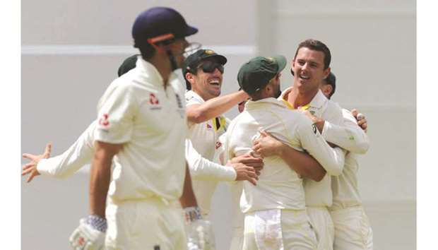 Australiau2019s Josh Hazlewood (second from right) celebrates after dismissing Englandu2019s Alastair Cook (left) on day four of the third Ashes Test in Perth yesterday. (AFP)