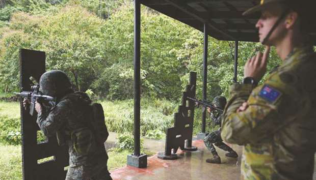 An Australian soldier (right) supervises as a Philippine Marine aims at targets during the Military Operation Urbanised Terrain (MOUTH) training exercises at the marine base in Ternate, Cavite province, southwest of Manila, yesterday. The training is part of the Australian governmentu2019s commitment to the Philippines in battling terrorism and to combat extremism.