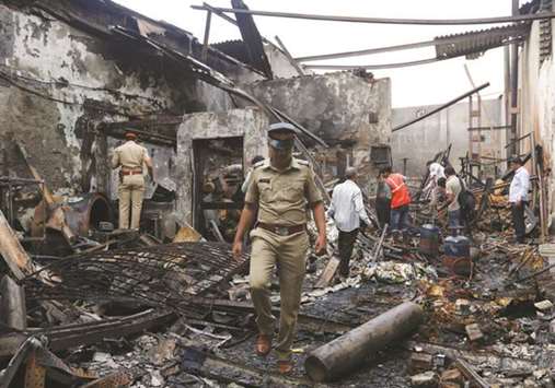 Policemen and rescue workers inspect the debris after a fire broke out at a snack factory in Mumbai yesterday.