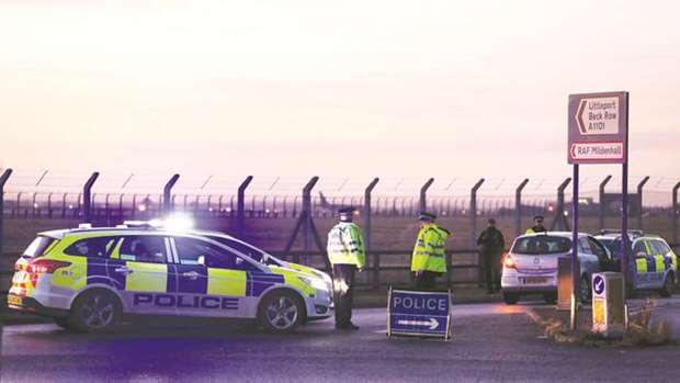 Police stand guard at the entrance to the US Air Force base at RAF Mildenhall, Suffolk, yesterday. US military personnel yesterday fired shots as they stopped a man who tried to force his way into the base. A security source, however, said it was not thought to be a terrorism incident. u201cShots were fired by American service personnel and a man has been detained with cuts and bruises and taken into custody,u201d Suffolk police said. u201cNo other people have been injured as a result of the incident.u201d