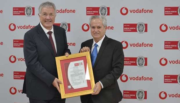 Gray (left) receives the ISO 27001:2013 re-certification from Kseib
