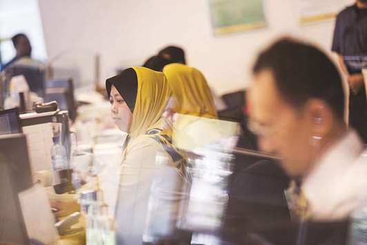 Employees work at a service counter inside a combined Malayan Banking (Maybank) and Maybank Islamic bank branch in Kuala Lumpur (file). Malaysia is expected to hold on to its lead as the largest sukuk issuer globally and retain its over-40% market share next year.