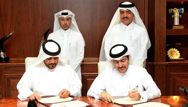 HE the Minister of Administrative Development, Labour, and Social Affairs Dr Issa bin Saad al-Jafali al-Nuaimi and HE the Minister of Municipality and Environment Mohamed bin Abdullah al-Rumaihi look on as the MME's Mohamed Ali al-Khuri and Barwa's Salman Mohamed al-Mohannadi sign the contract.