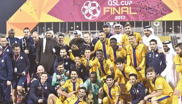 Al Gharafa players and officials pose after winning the QSL Cup yesterday. Pictures: Noushad Thakkayil