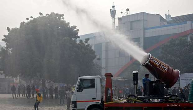 A man operates an ,anti-smog gun,, a machine that sprays atomised water into the air to reduce pollution
