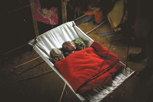 A Rohingya refugee baby girl sleeps inside her familyu2019s temporary shelter at the Balukhali camp.