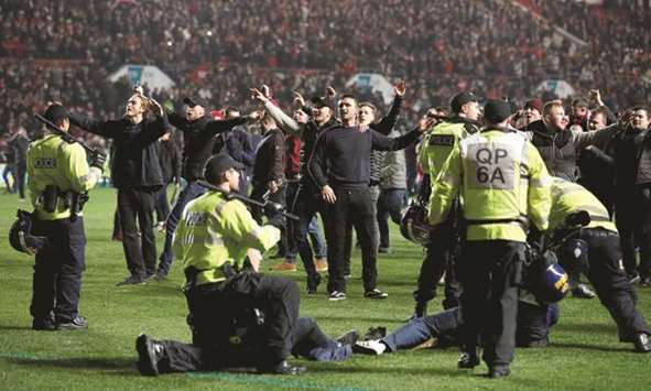 Police apprehend Bristol City fans as they invade the pitch after their League Cup quarter-final against Manchester United in Bristol on Wednesday. (Reuters)