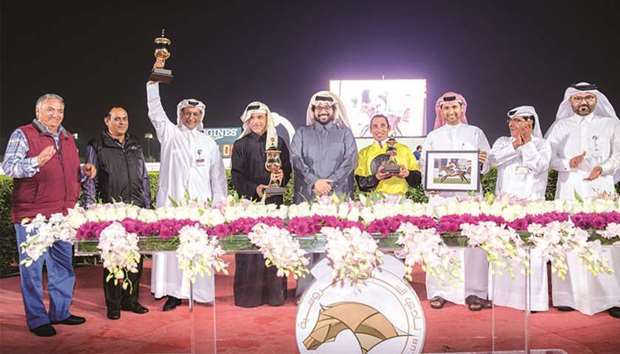 Trainer Rashid Mohamed al-Jehani (third from left) hoists his trophy as Qatar Racing and Equestrian Club general manager Nasser Sherida al-Kaabi (centre), QREC deputy chief steward Abdulla Rashid al-Kubaisi and others look on during the prize distribution ceremony for the HH Sheikh Mohamed Bin Khalifa Al Thani Trophy (Gr2). Courtofversailles won the 2000m turf feature for Thoroughbreds yesterday.