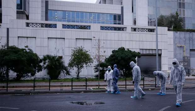 Police officers search for evidence after a bomb blast at a court building in Athens