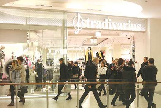 Shoppers pass in front of a Stradivarius fashion clothing store in Moscow. While the bustle of Russians shopping might sound like a harbinger of economic recovery, itu2019s actually a sign people are more willing to cut down on savings and borrow for the purchases theyu2019ve delayed for years.