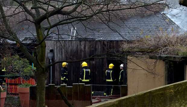 Firefighters stand near a building at London Zoo following a fire which broke out at a shop and cafe at the attraction, in central London