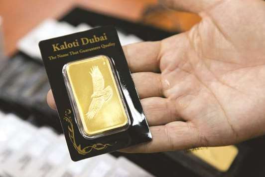 An employee displays a small gold bar in u201cKaloti Dubaiu201d packaging at the Kaloti Jewellery factory in Sharjah June 30, 2013. A former Ernst & Young partner, who says he blew the whistle on suspected irregularities at Dubai gold refiner Kaloti, sued the accounting firm for suppressing his findings and failing to protect him from possible retaliation.