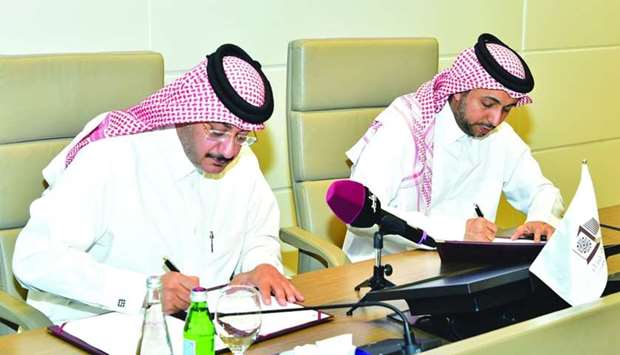 Dr Hassan al-Derham and Faleh al-Naemi signing the MoU.