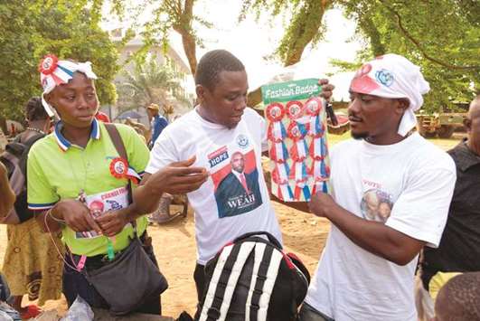 Street vendors attempt to sell election items to supporters of Liberiau2019s Presidential Candidate and ex-footballer George Weah outside his Coalition for Democratic Change (CDC) party headquarters in Monrovia yesterday.