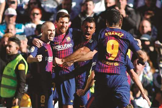 Barcelonau2019s star forward Lionel Messi (second left) celebrates with teammates Andres Iniesta (left), Paulinho and Luis Suarez after scoring against Real Madrid at the Santiago Bernabeu stadium. (AFP)