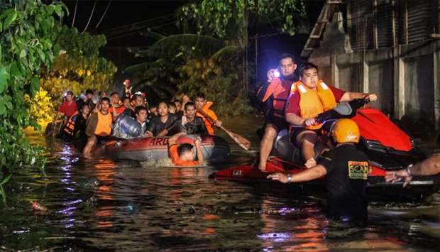 Rescue workers evacuate flood-affected residents in Davao